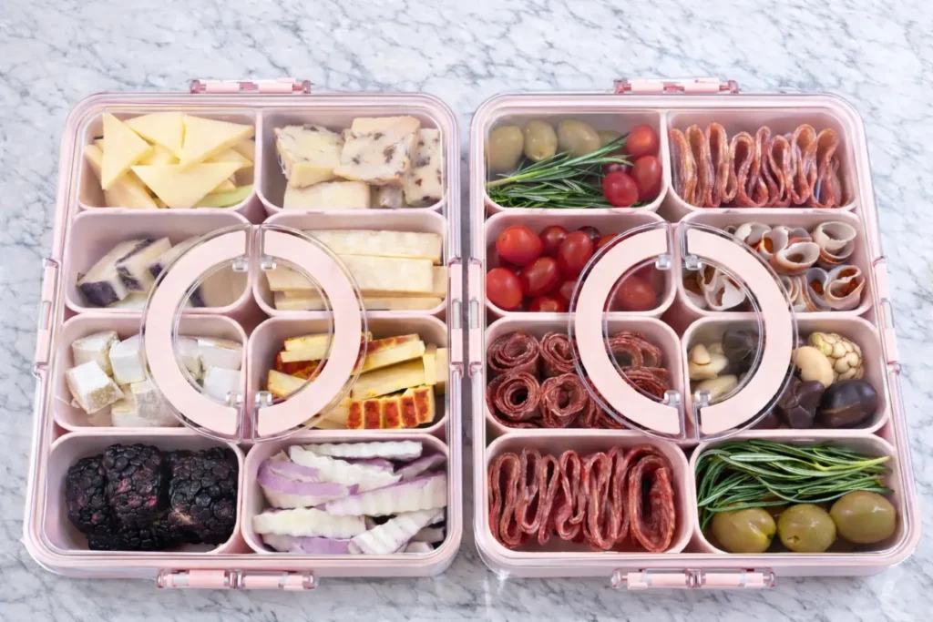 A divided snackle box packed with crackers, candy, fruit, and snack mix
