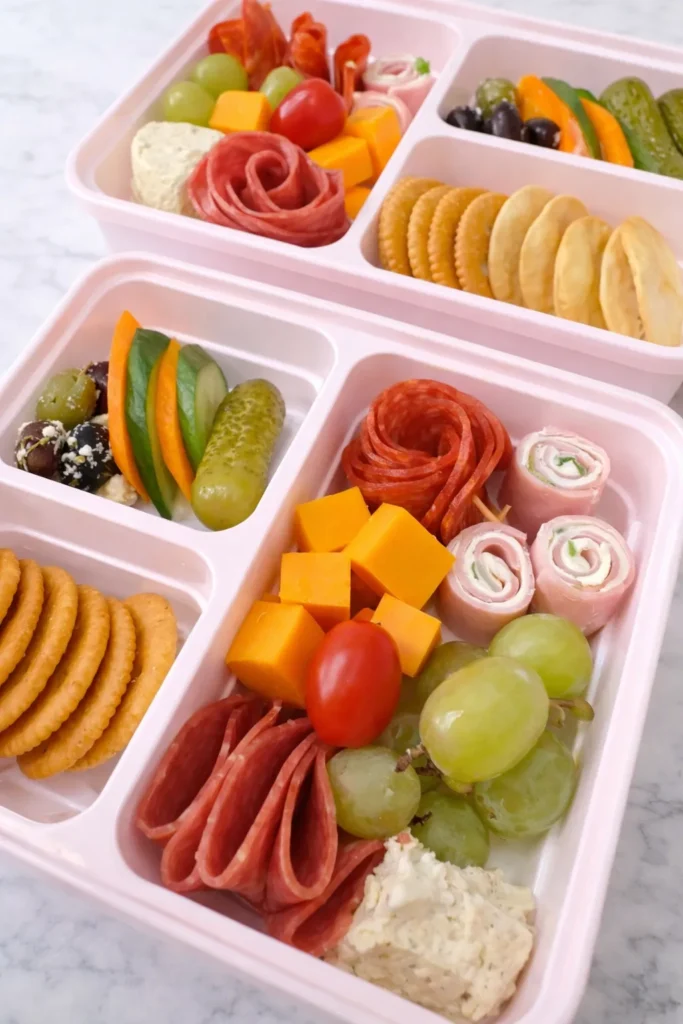 A compartment snack box filled with mixed snacks including candy, crackers, and nuts